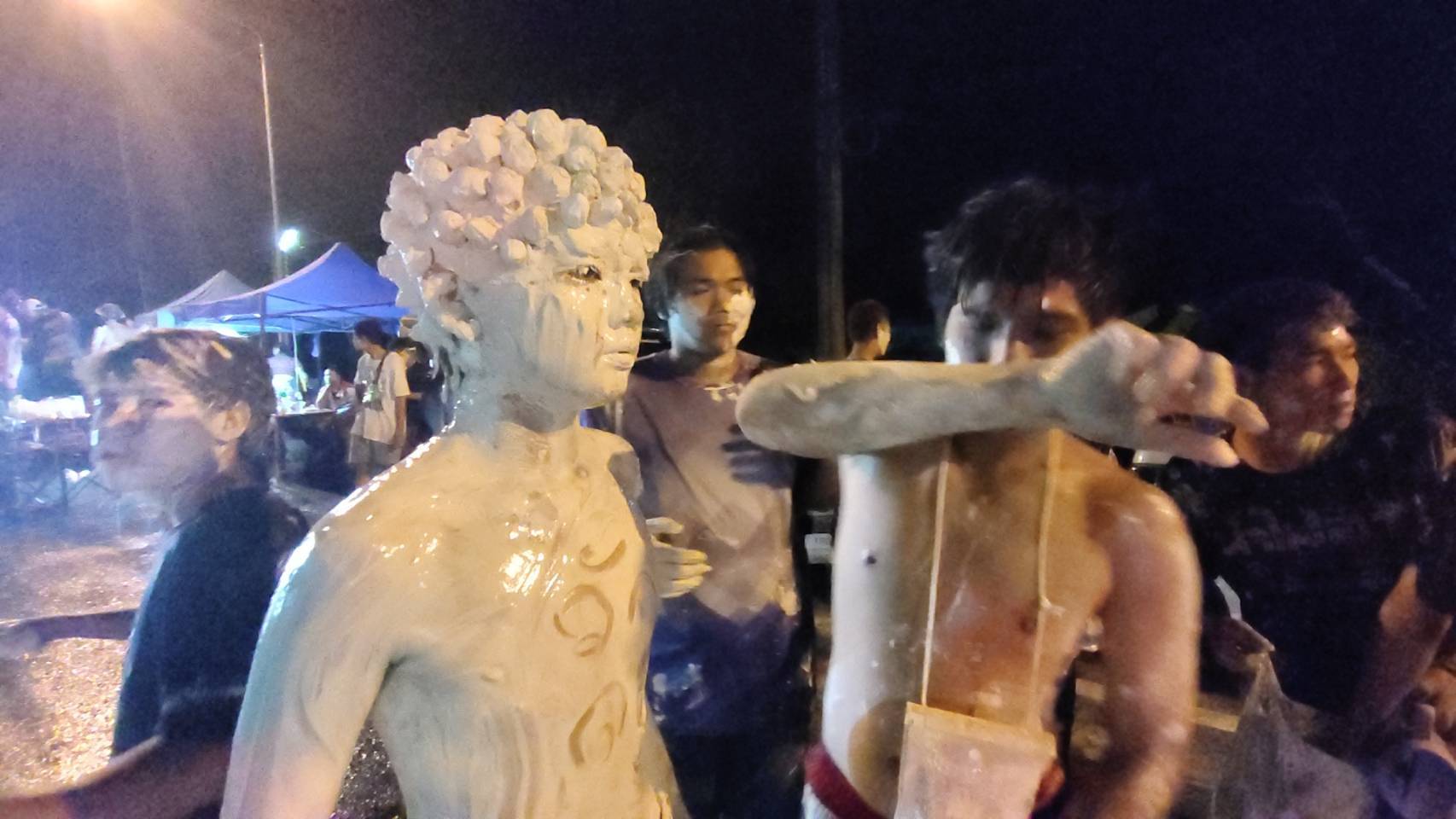 วันไหลนครนายก คึกคัก เด็กหนุ่มใช้ดินสอพอง ทาตัวแต่งเป็นเงาะป่าผิวขาว