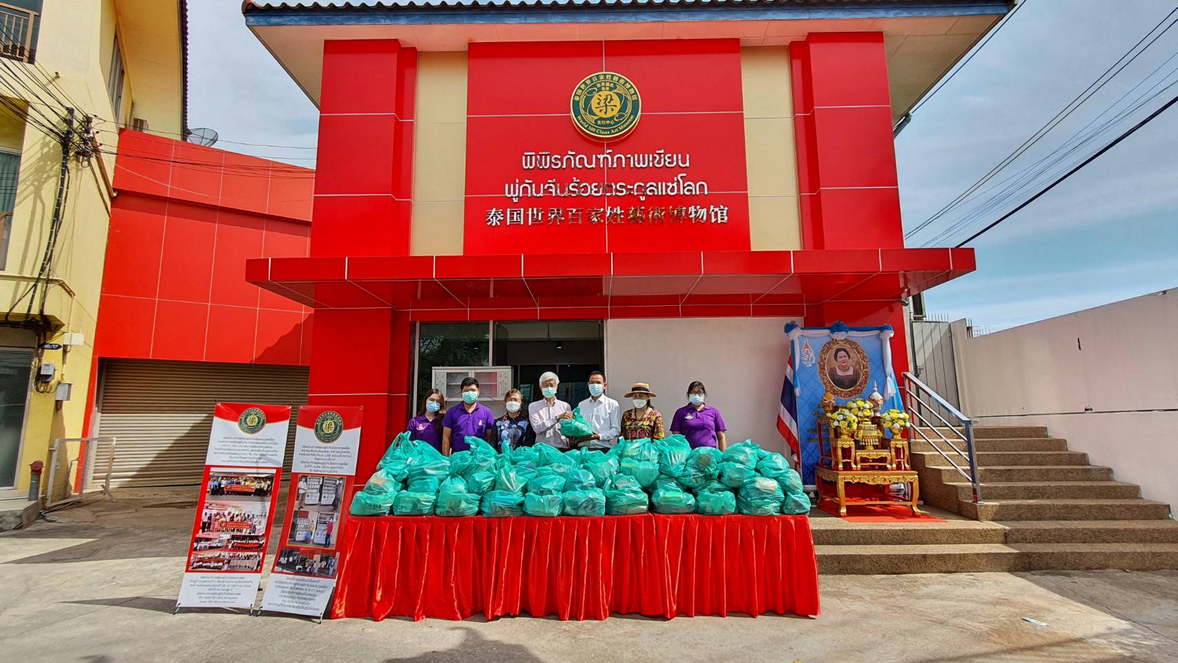 ประธานสภาวัฒนธรรมอำเภอเมืองฯ รับมอบของจากประธานพิพิธภัณฑ์  ภาพเขียนพู่กันจีนร้อยตระกูลแซ่โลก "งานทิ้งกระจาด"