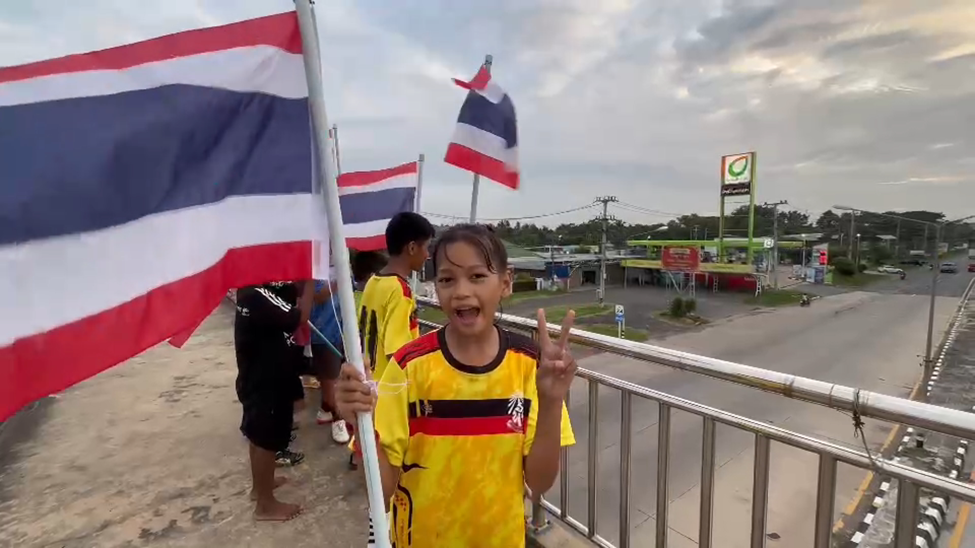 บุรีรัมย์ นร.ประถมขึ้นสะพานลอยสะบัดธงไทยให้รถทหารที่เดินทางไปรบ
