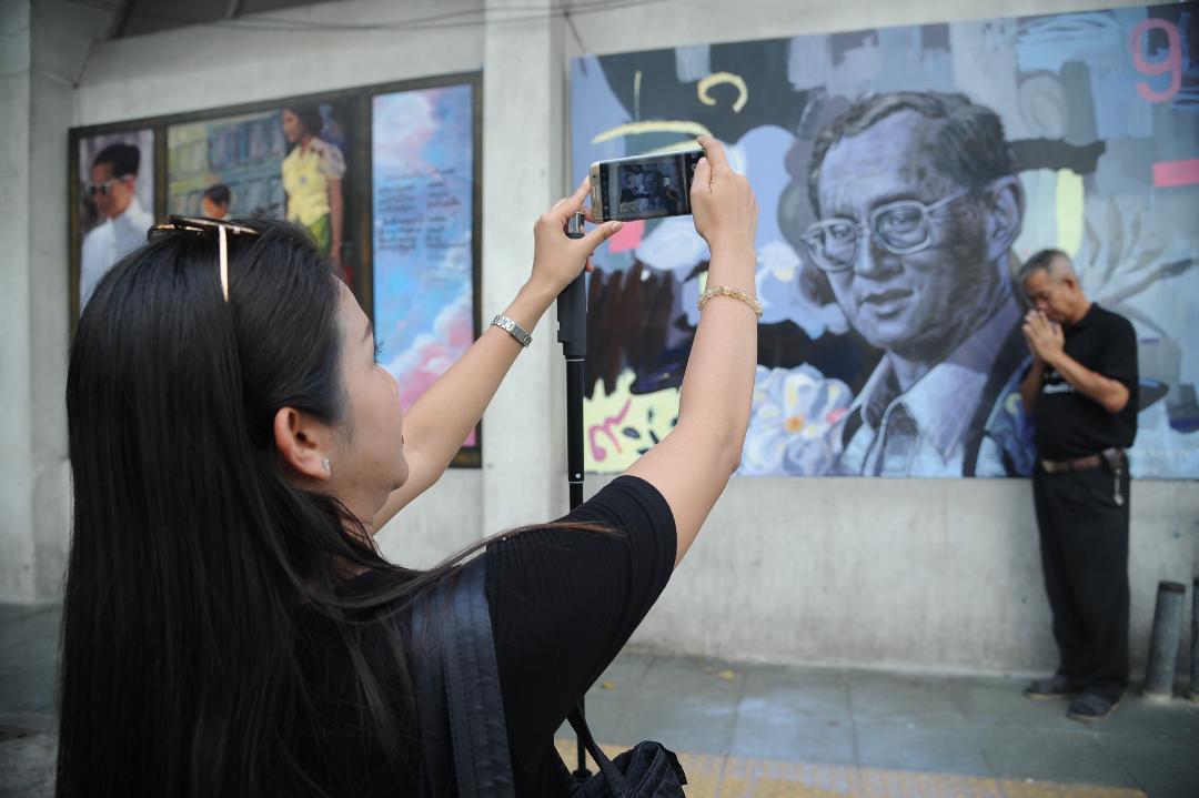 ประชาชนให้ความสนใจถ่ายรูปกับภาพวาดพระบรมสาทิสลักษณ์รูปในหลวง ร.9 บริเวณท่าพระจันทร์