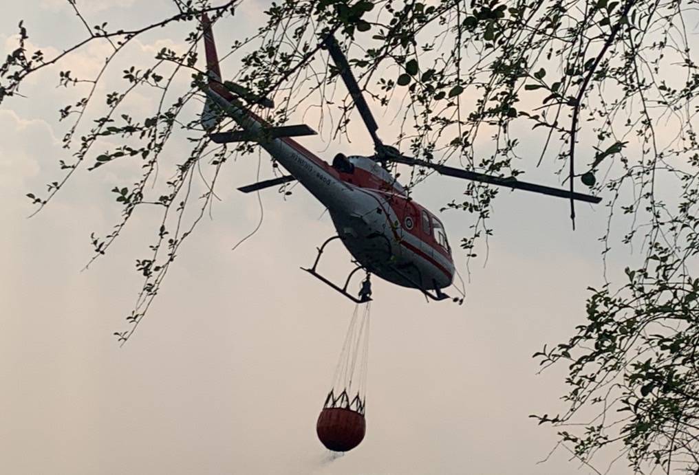 เฮลิคอปเตอร์บินตักน้ำดับไฟป่าบริเวณเขาสูงชัน พื้นที่เขตรักษาพันธุ์สัตว์ป่าแม่ตื่น