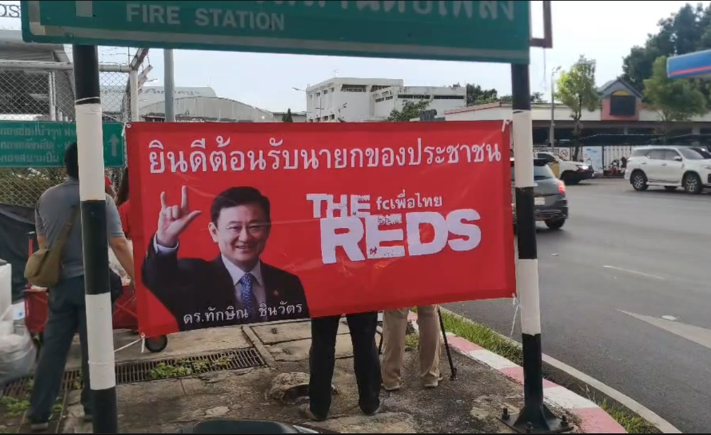 กลุ่มคนเสื้อแดง ยึดพื้นที่รอบสนามบินดอนเมือง พร้อมติดป้ายต้อนรับ “ทักษิณ” กลับไทย 