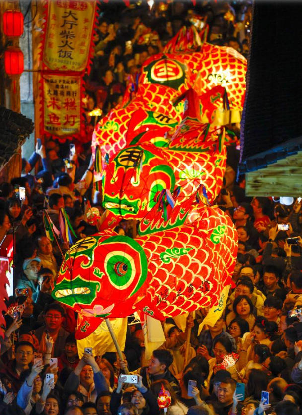 14 กุมภาพันธ์ - คณะการแสดงโคมปลาจัดขบวนแห่ไปตามตรอกซอกซอย ในหมู่บ้านจานฉี ตำบลเป่ยอั้น อำเภอเซ่อเสี้ยน เมืองหวงซาน มณฑลอันฮุย (ภาพ ซินหัว)