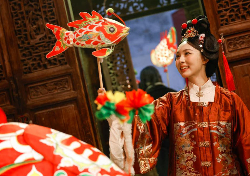 14 กุมภาพันธ์ - นักท่องเที่ยวถือโคมปลาถ่ายภาพเป็นที่ระลึก ในหมู่บ้านจานฉี ตำบลเป่ยอั้น อำเภอเซ่อเสี้ยน เมืองหวงซาน มณฑลอันฮุย (ภาพ ซินหัว)