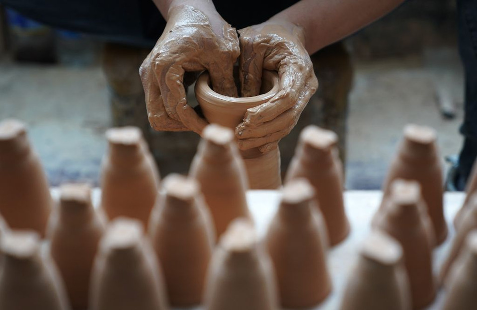 ภาพช่างฝีมือกำลังปั้นขึ้นรูปดินบนแป้นหมุน ภายในโรงทำเครื่องกระเบื้องแห่งหนึ่งในเมืองจิ่งเต๋อเจิ้น มณฑลเจียงซี  เมื่อวันที่ 28 สิงหาคม 2024 (ภาพโดย สำนักข่าวซินหัว)
