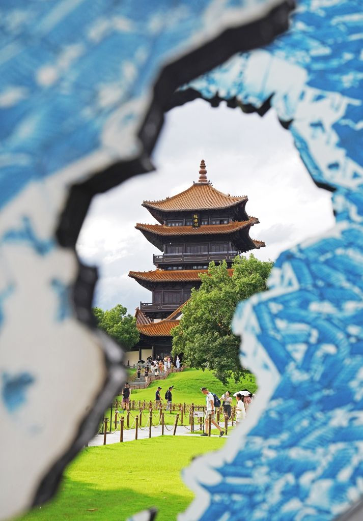 ภาพหอหลงจู (Longzhu Pavilion) ที่มองผ่านจานกระเบื้องเคลือบสีน้ำเงิน-ขาว (ชิงฮวา) ดีไซน์สร้างสรรค์ ในเมืองจิ่งเต๋อเจิ้น มณฑลเจียงซี เมื่อวันที่ 7 กรกฎาคม 2026 (ภาพโดย สำนักข่าวซินหัว)