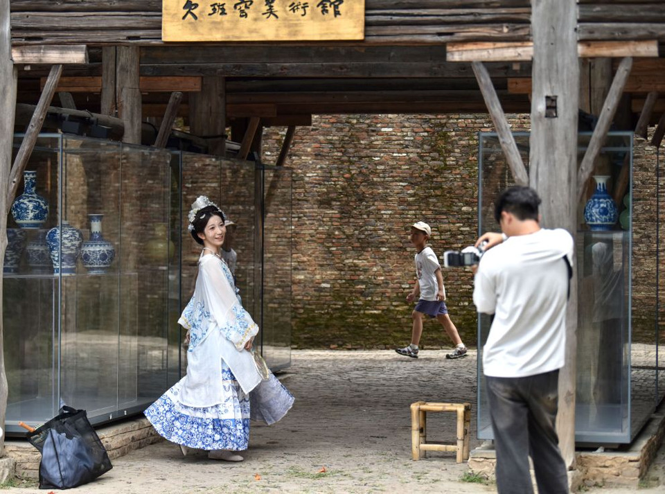 ภาพนักท่องเที่ยวร่วมถ่ายรูปเป็นที่ระลึก บริเวณย่านประวัติศาสตร์และวัฒนธรรมเถาหยางหลี่ ในเมืองจิ่งเต๋อเจิ้น เมื่อวันที่ 17 กรกฎาคม 2025 (ภาพโดย สำนักข่าวซินหัว)