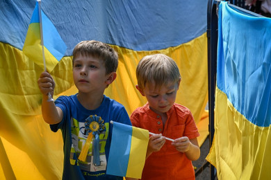 เด็กชาวยูเครน ถือธงชาติยูเครน (Photo : AFP)