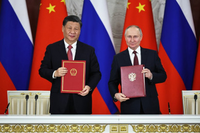 ประธานาธิบดีสี จิ้นผิง แห่งจีน (ซ้าย) พร้อมด้วยประธานาธิบดีวลาดิเมียร์ ปูติน แห่งรัสเซีย โชว์สนธิสัญญาฉบับใหม่ที่ทั้งสองร่วมลงนาม (Photo : AFP)